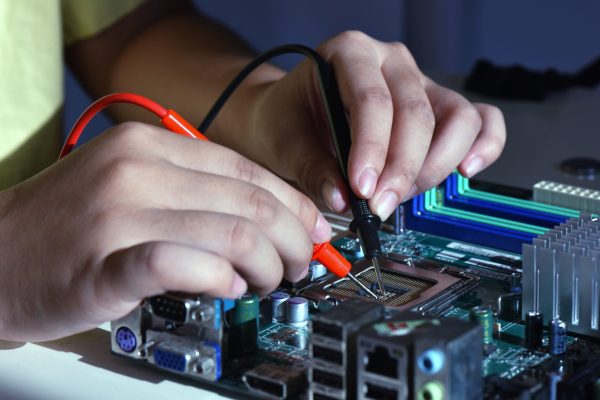 Close up hands of needle tipped tip service worker repairing cpu computer. Repairing and service concept